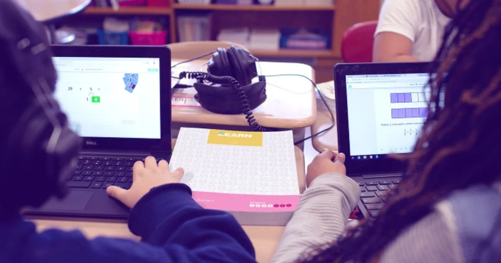 Zearn curriculum map with two people working on laptop